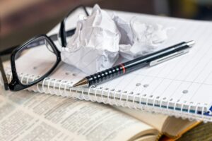 a book and notebook with a crumpled page, indicating frustration with a deal breaker.