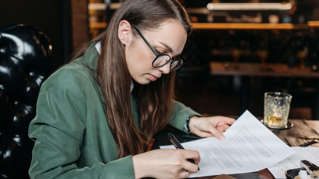 Businesswoman signing formation documents at her desk