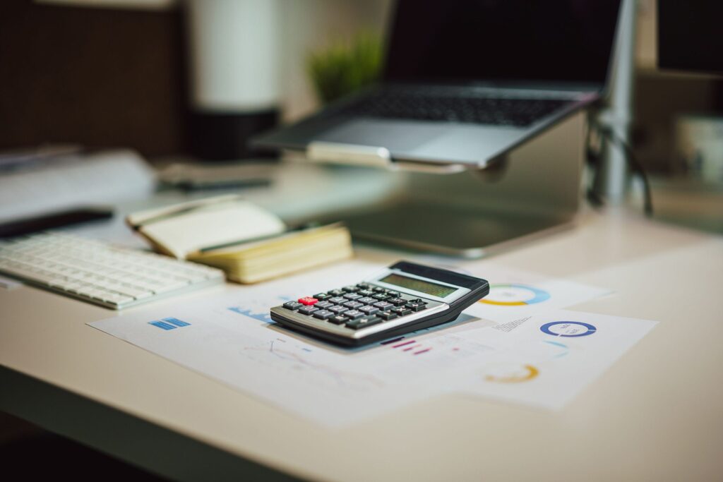 Laptop, calculator and financial reports on an accountant's desk