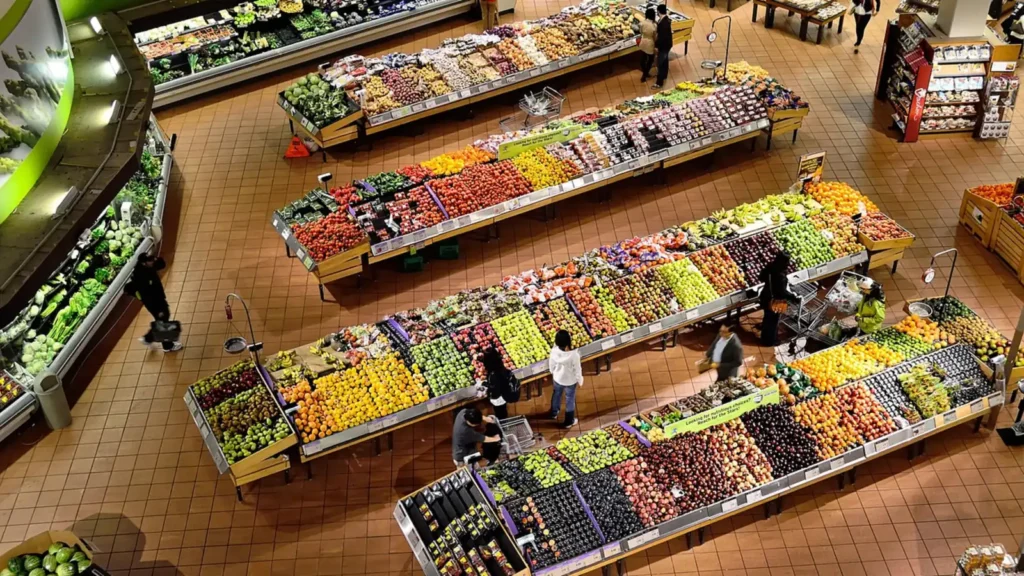 Overhead view of a grocery store produce section with colorful fruit and vegetable stalls
